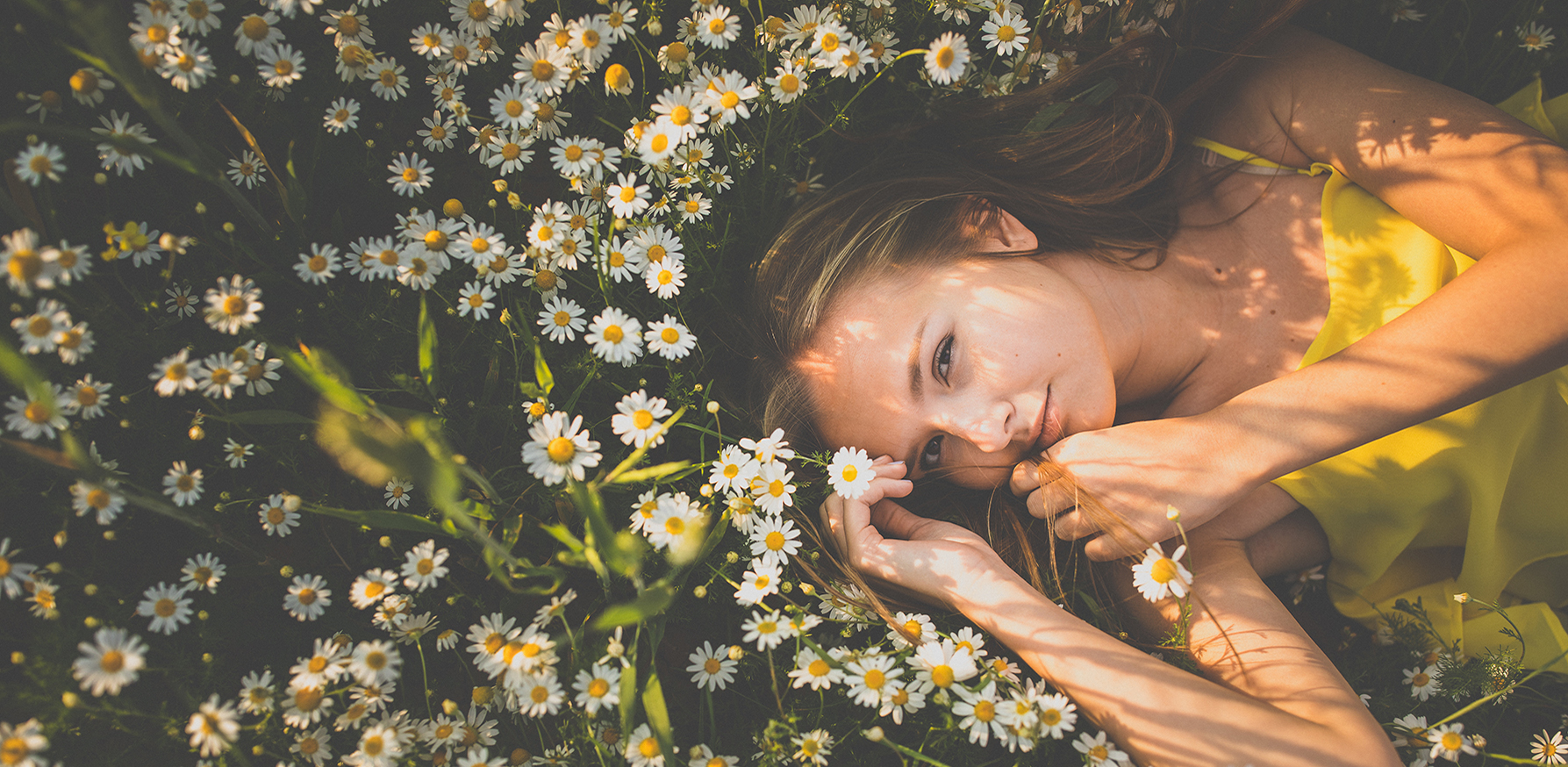 what-is-biotech-beauty-how-to-incorporate-it-woman-in-field-of-flowers