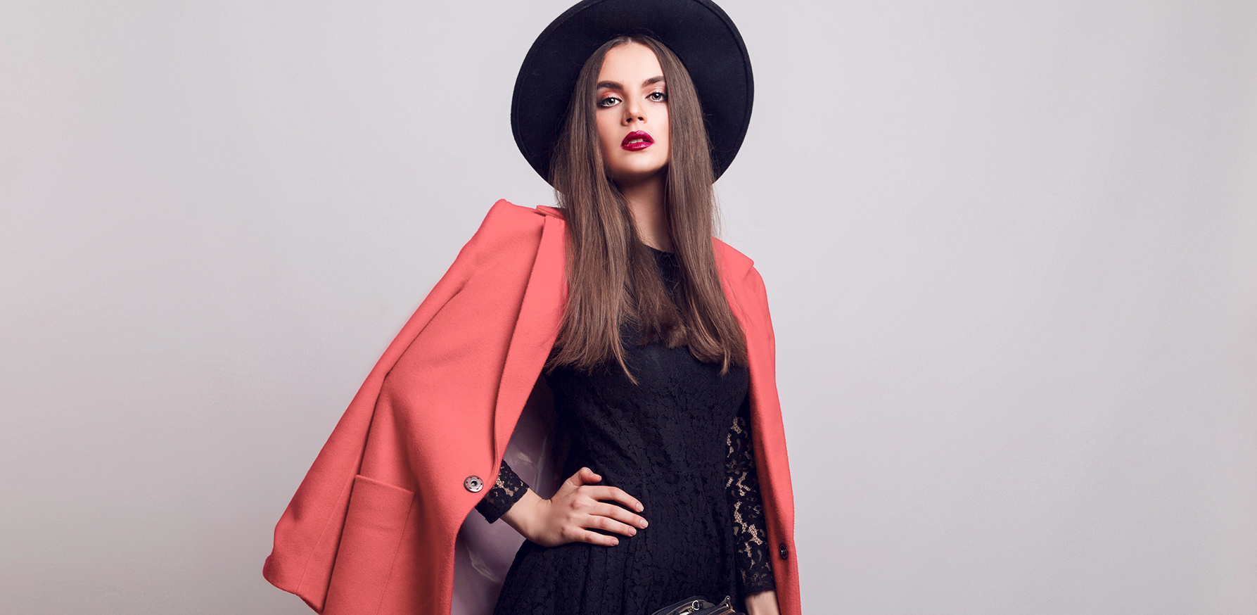 inclusivity-in-the-beauty-world-fashionable-woman-standing-in-pink-coat-and-black-hat
