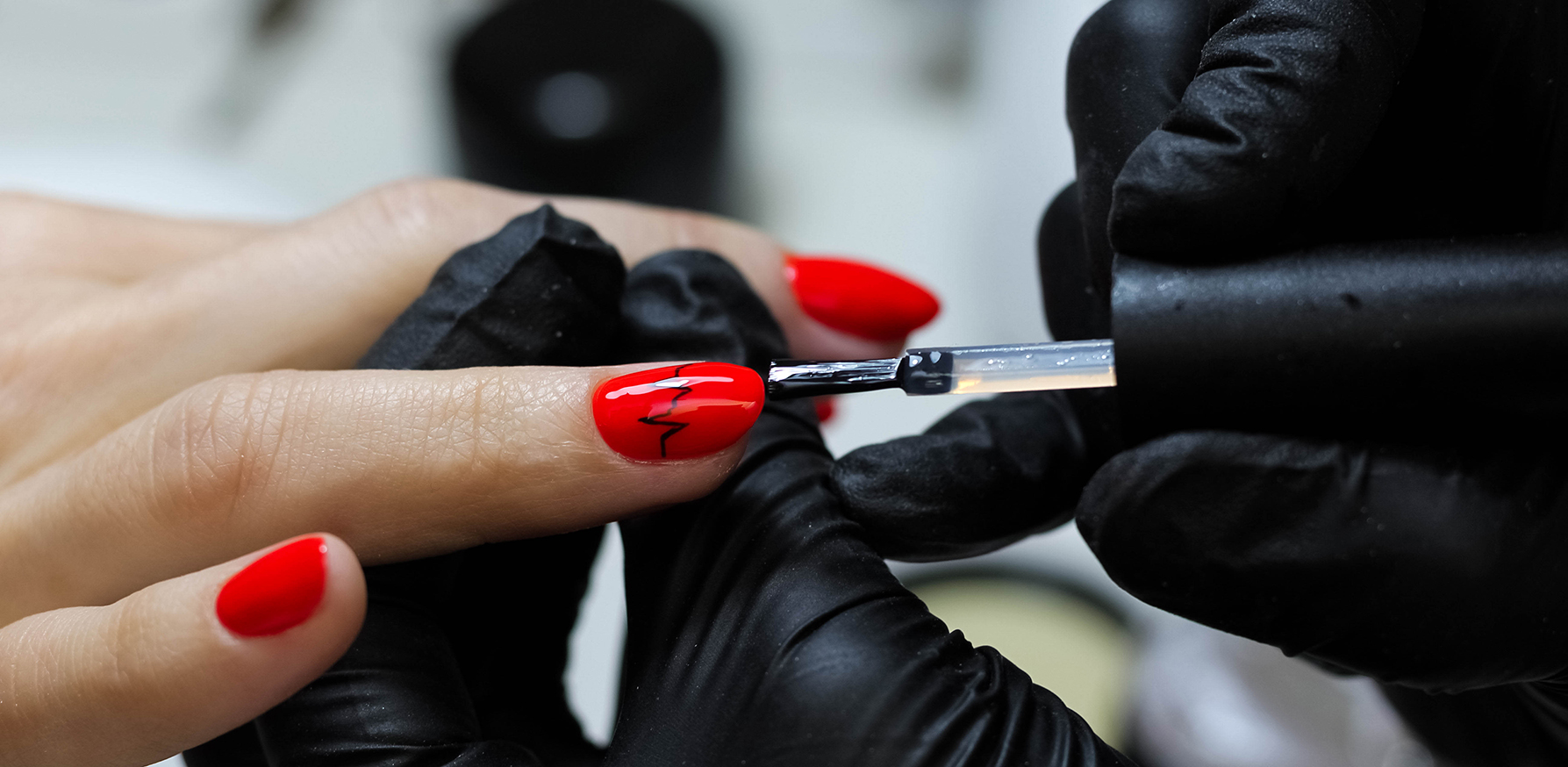 how-to-properly-care-for-your-cuticles-woman-with-red-nails-getting-manicure-main-image