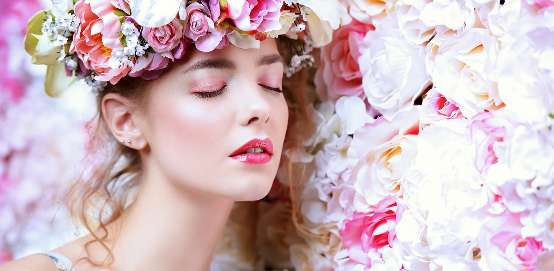 feminine-fragrances-for-spring-woman-in-flower-crown-against-flower-wall