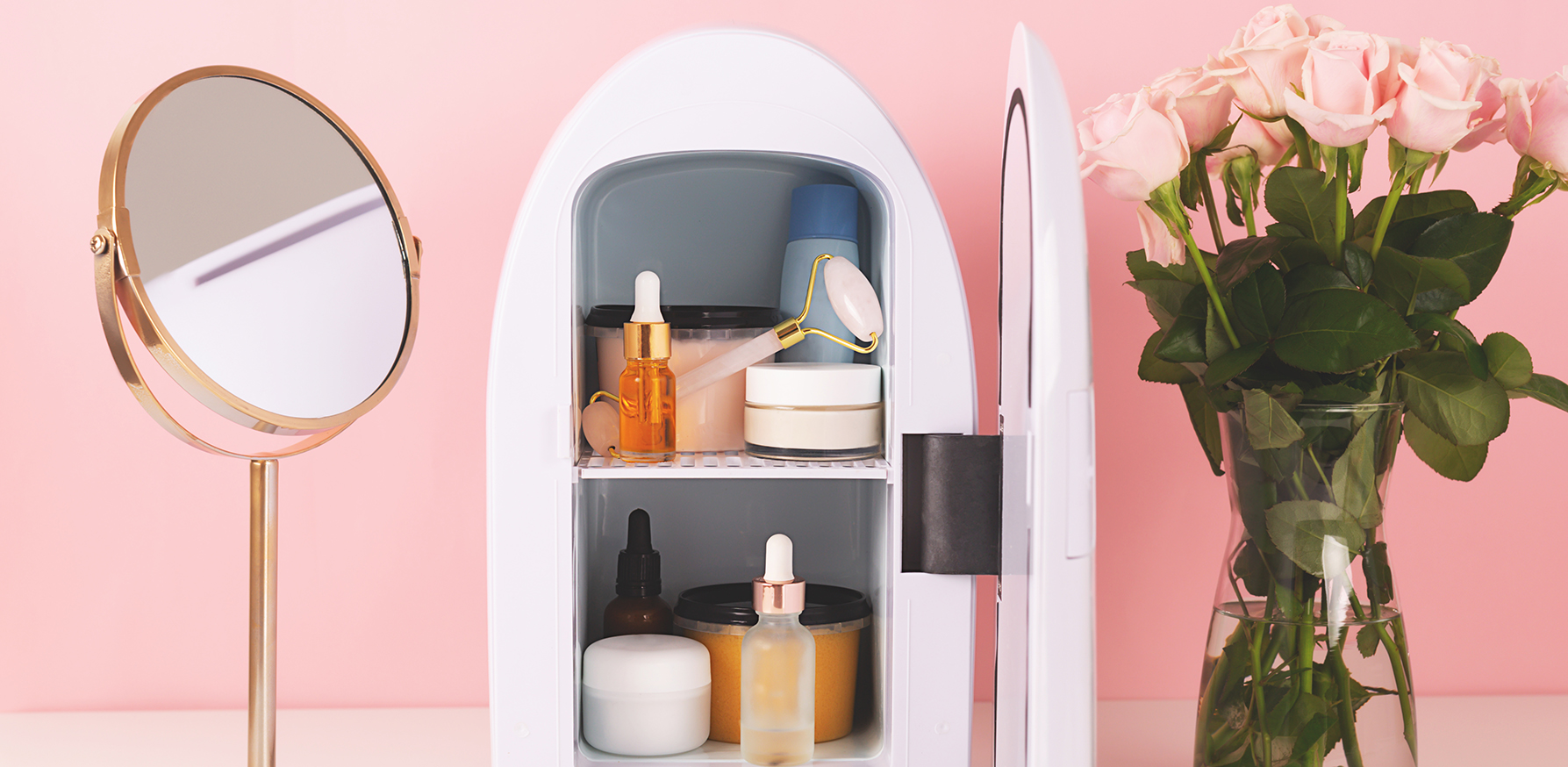 should-you-own-a-skin-care-fridge-fridge-with-skincare-in-front-of-pink-background